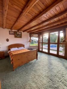 a bedroom with a bed in a room with windows at Quinta Suria in Quito