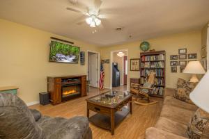 a living room with a couch a table and a fireplace at Across from Dollywood w FREE Dollywood ticket, pets ok wfee, arcade, hot tub in Pigeon Forge