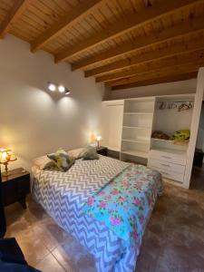 1 dormitorio con 1 cama con edredón azul y blanco en Casa Vivienda Familiar Ituzaingo Centro Parque en Ituzaingó
