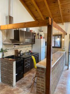 a kitchen with a stove and a counter with a yellow chair at Casa Vivienda Familiar Ituzaingo Centro Parque in Ituzaingó +20 photos