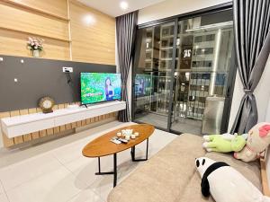 een woonkamer met een bank en een tv bij Homestay Vinhomes Ocean Park S209 in Ða Tốn