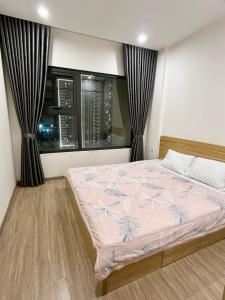 een slaapkamer met een bed en een raam bij Homestay Vinhomes Ocean Park S209 in Ða Tốn