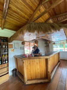 基多的住宿－Quinta Suria，站在小木屋木酒吧的男人
