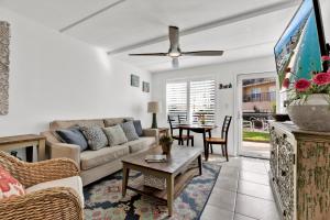 a living room with a couch and a tv at Beachside Bungalow: Surfside I #104 in South Padre Island