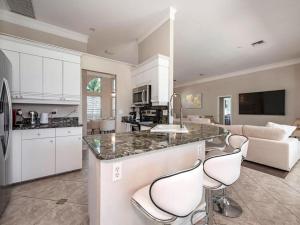 a kitchen with two bar stools and a counter top at Lux Family 3 BR With Pool Villa Walk To Beach and Mercato in Naples