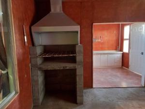 a kitchen with a brick oven in a room at Cabañas con tinajas coronel in Coronel