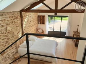 a bedroom with a bed in a room with a window at Gîte de Charme à Senlisse: Confort Haut de Gamme, Parc Arboré, Cheminée, Wifi Gratuit, Proche Châteaux - FR-1-527-9 in Senlisse