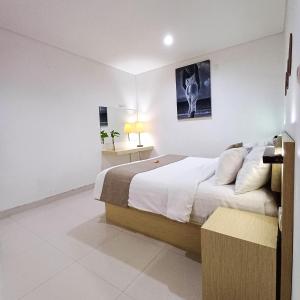 um quarto branco com uma cama e uma fotografia na parede em Harmony Beach Suite em Seminyak