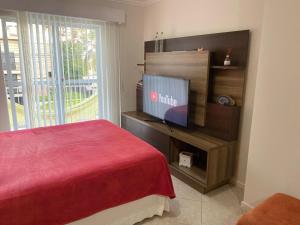 a bedroom with a bed and a television on a stand at Lar doce lar da Lu in Curitiba