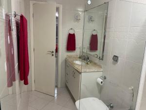 a bathroom with a toilet and a sink and a shower at Lar doce lar da Lu in Curitiba