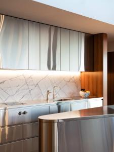 een keuken met witte kasten en een wastafel bij 'Hobart' - Waterfront penthouse with private heated pool in Hobart