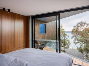 een slaapkamer met uitzicht op het water bij 'Hobart' - Waterfront penthouse with private heated pool in Hobart