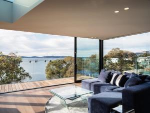 een woonkamer met uitzicht op het water bij 'Hobart' - Waterfront penthouse with private heated pool in Hobart