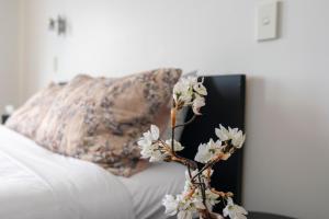 a vase with white flowers on a white couch at Cathedral Junction Apartments in Christchurch