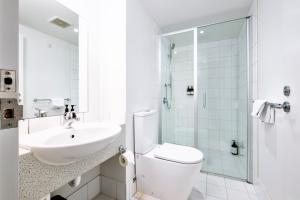 a bathroom with a sink and a toilet and a shower at Cathedral Junction Apartments in Christchurch