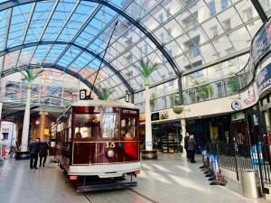 a trolley in a mall with a glass ceiling at Cathedral Junction Apartments in Christchurch