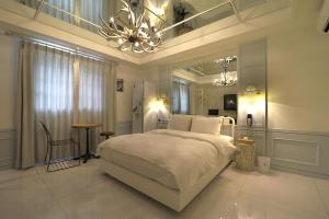 Un dormitorio con una gran cama blanca y una lámpara de araña. en Songdo February Hotel Amnam en Busan