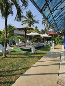 een resort met tafels, parasols en stoelen bij Thai Garden​ Resort​ Kanchanaburi​ in Kanchanaburi