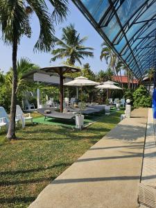 a resort with tables and umbrellas and chairs at Thai Garden​ Resort​ Kanchanaburi​ in Kanchanaburi City