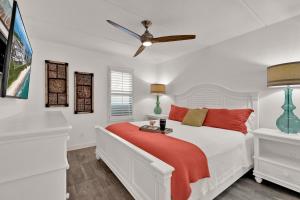 a white bedroom with a bed with a red blanket at Seagull's Landing By The Ocean in South Padre Island +27 photos