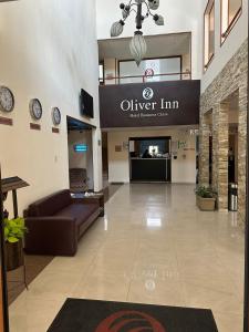 a lobby of an office with a couch and clocks at Hotel Oliver Inn - Business Class in Querétaro