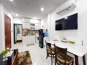 eine Küche mit einem Esstisch und einem TV an der Wand in der Unterkunft Apartment 285 Đội Cấn, Hà Nội in Hanoi