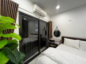 ein Schlafzimmer mit einem Bett und ein Zimmer mit einem Balkon in der Unterkunft Apartment 285 Đội Cấn, Hà Nội in Hanoi