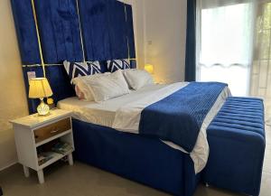 Schlafzimmer mit einem großen Bett mit blauem Kopfteil in der Unterkunft Stay with Tiffany 3 in Daressalam