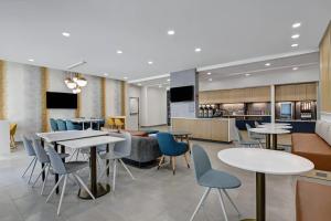 un restaurante con mesas y sillas y una cocina en TownePlace Suites by Marriott Sumter, en Sumter