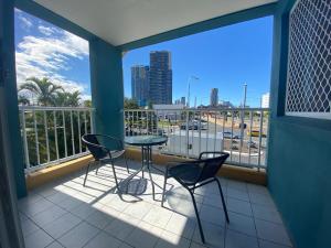 uma varanda com mesa e cadeiras e vista para a cidade em Homely Inn Hostel em Gold Coast