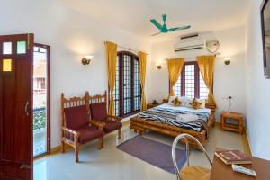 een slaapkamer met een bed en een stoel bij Peter's Inn in Cochin