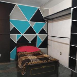 1 dormitorio con 1 cama con pared azul y negra en Habitaciones ampliación piloto, en Ciudad de México