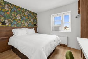 a bedroom with a large white bed and a window at Uptown Inn by Vantaggio Suites in San Diego