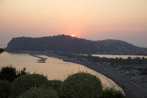 a view of a river with the sun setting on a hill at Hotel Cala Moresca in Bacoli