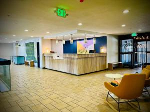 a lobby with a waiting area with chairs and a counter at Greenwood Inn in Greenwood Village