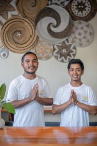 two men standing in front of a table with their hands at Tanis Village - Luxury Villas in Gili Air