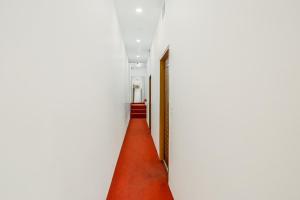 バティンダにあるOYO Dr Plazaの赤い絨毯と扉の廊下