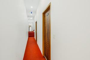 バティンダにあるOYO Dr Plazaの赤い絨毯が敷かれた廊下
