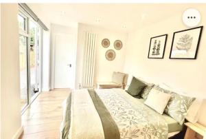 a white bedroom with a bed and a window at Stunning 1 bedroom and double sofa bed near Train station in Southampton