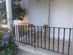 ein schmiedeeisernes Geländer auf einer Veranda mit 2 Stühlen in der Unterkunft Hotel Cabo Festiñanza in Sanxenxo