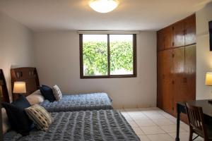 um quarto com uma cama e uma janela em Villa Nola em Guatemala