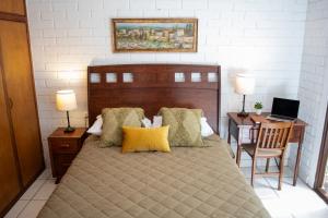 a bedroom with a bed and a desk with a laptop at Villa Nola in Guatemala