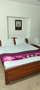 een slaapkamer met een groot bed en een paarse deken bij Deep Jungle Stays in Ooty