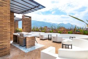 a patio with white furniture and mountains in the background at Morph Chicó in Bogotá