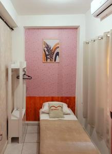 ein Schlafzimmer mit einem Bett und einer rosa Wand in der Unterkunft Matianellu SP in São Paulo