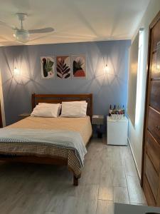 特雷索波利斯的住宿－Chalé Shakti，卧室配有一张床,墙上挂有绘画作品