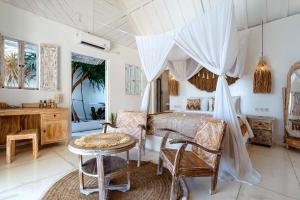 珀尼达岛Atalaya Villas Nusa Penida - Adults only的一间卧室，配有一张床、一张桌子和几把椅子