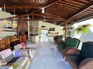 ein Wohnzimmer mit Sofas und Stühlen auf einer Terrasse in der Unterkunft Casa Pekó Barra de São Miguel (5 suítes) in Barra de São Miguel