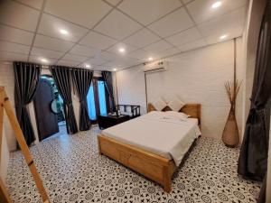ein Schlafzimmer mit einem Bett und einem Stuhl in einem Zimmer in der Unterkunft GOLDEN LOTUS SPA & HOMESTAY in Ấp Thiện Phước
