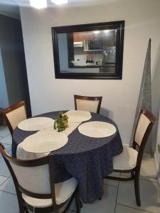 a dining room table with chairs and a mirror at Arica verano y surf Dpto completo 2 habitaciones in Arica